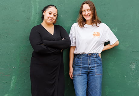 An image of Chantelle and Aisling infront of a green wall