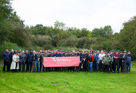 An image of Volunteers from St Joseph in a field holding the Berkeley Foundation logo