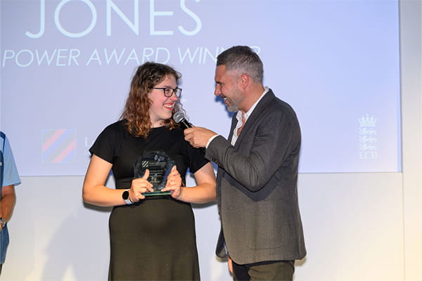 Piers Clanford on stage presenting an award to an affliate of Super 1.