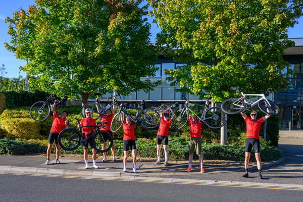 Berkeley employees and affiliates taking a group photo in Birmingham along a roadside.
