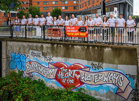 Berkeley employees and affiliates taking a group photo in Birmingham along a roadside.
