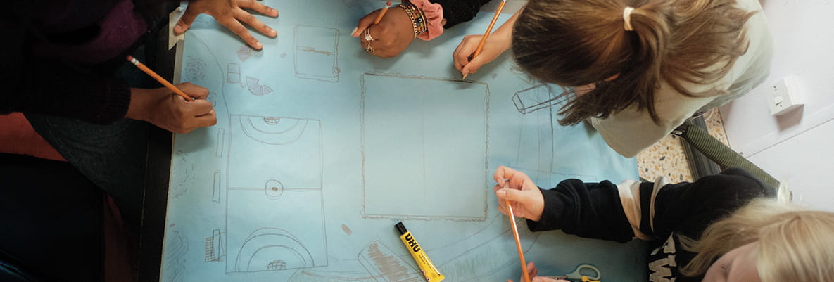 An aerial top down view image of a group of children drawing a picture together